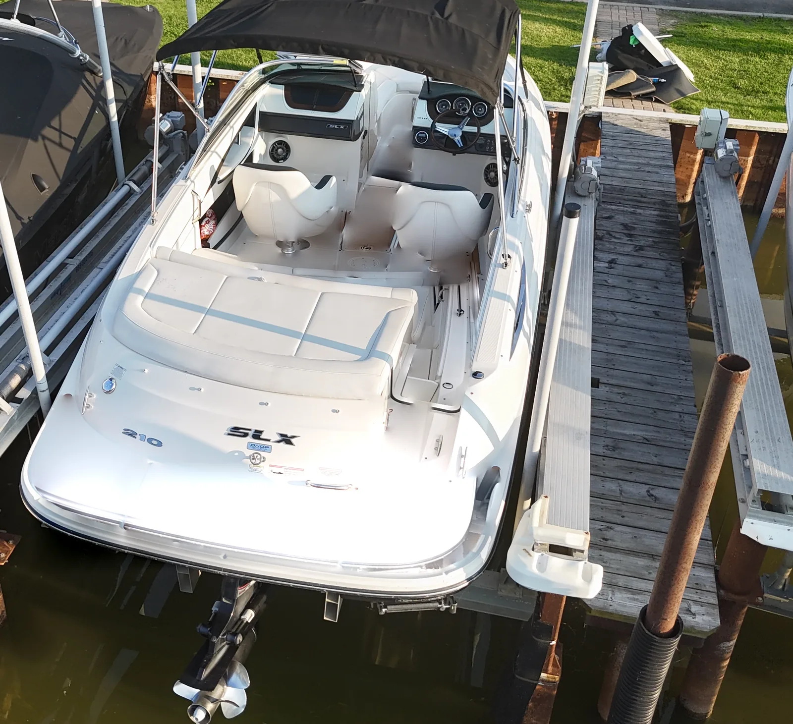 A 2014 Sea Ray 210 SLX on its lift, seen from above, with a bare white deck